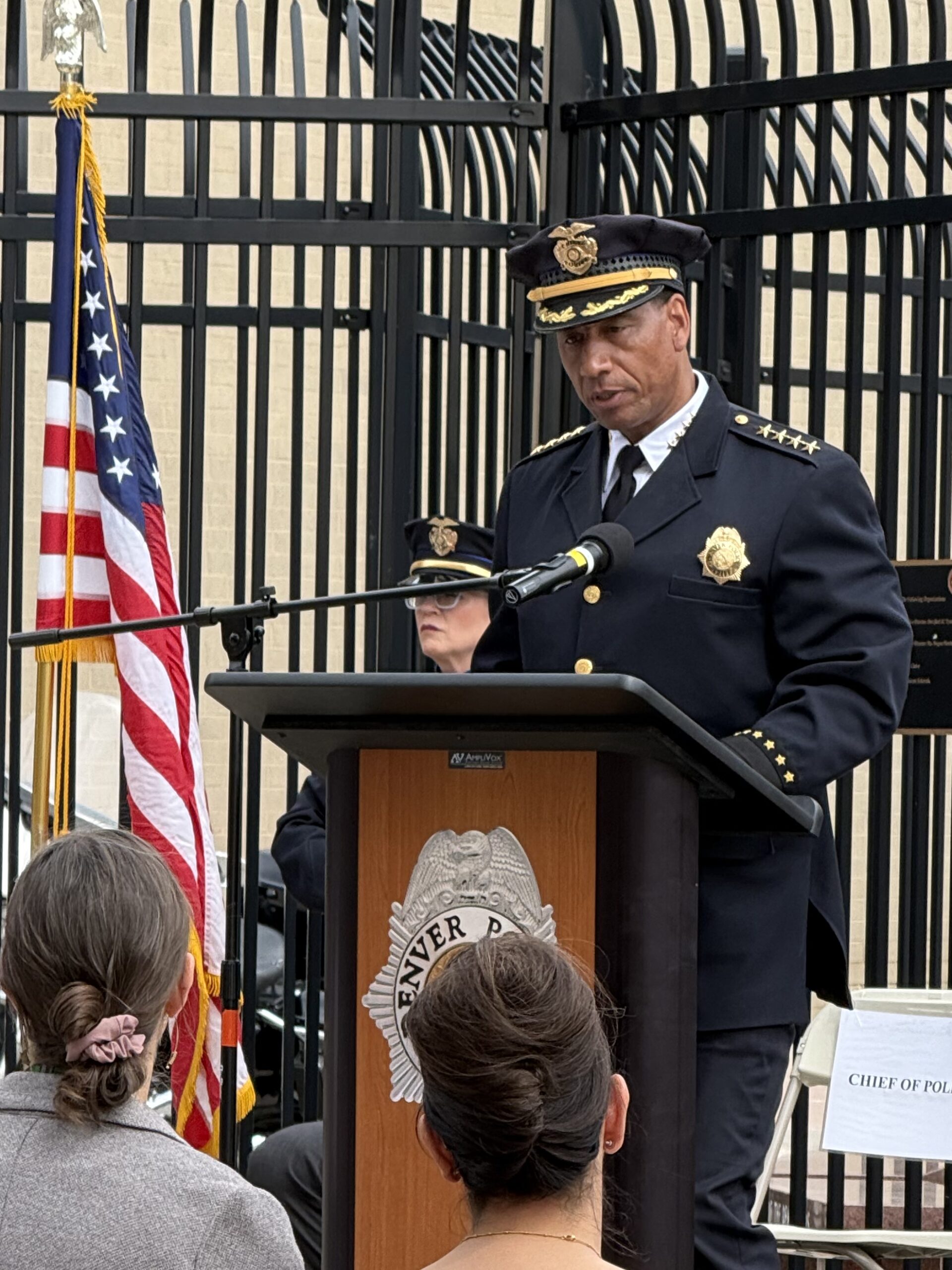 The chief of police standing at a podium speaking into a microphone